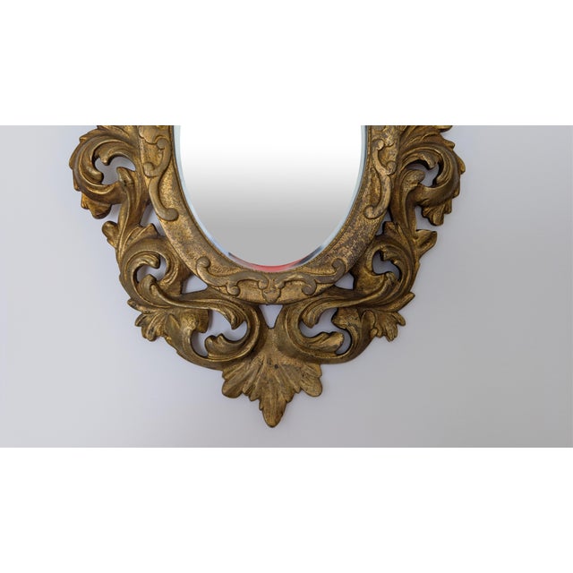 An elegant early 20th-century French gilt bronze wall mirror featuring an ornate Rococo Revival frame surrounding a...