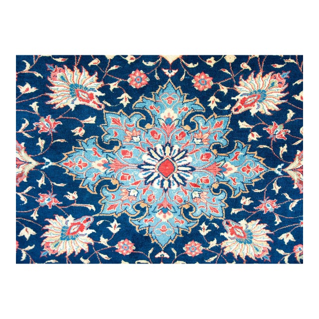 A beautiful mid-20th century Persian Sarouk rug with a central flower with trailing vines with more large flowers and...