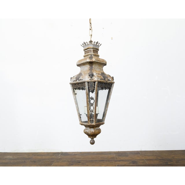 An Italian tôle four-light lantern from the 19th century with patinated finish, palmette motifs and glass panels. This...