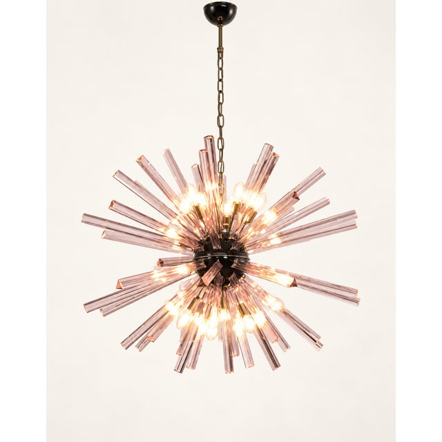 Italian Sputnik chandelier with 50 trihedral prisms in pink glass. The elements radiate from a black metal core, forming a...