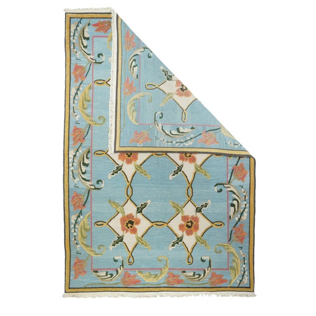 With an interlace allover two by three pattern on light blue and cream. Pale blue border with large acanthus leaves...