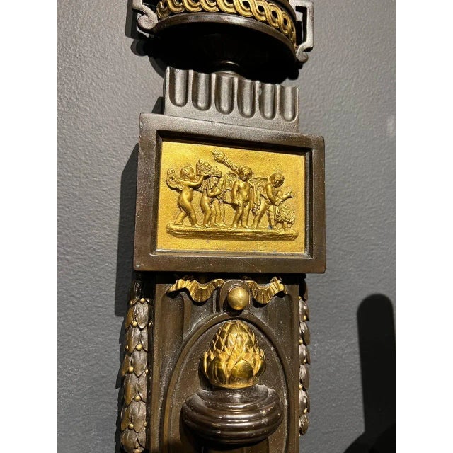 A pair of circa 1920’s Caldwell sconces with neoclassical design, brown patinated finish and gilt metal