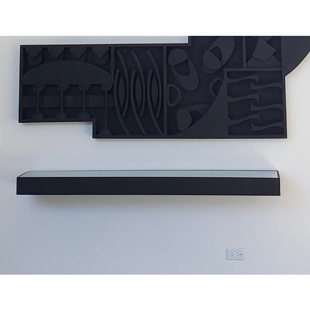 One-of-a-kind black floating wall mounted wood shelf with carved wood elements that are reminiscent of Louise Nevelson's...