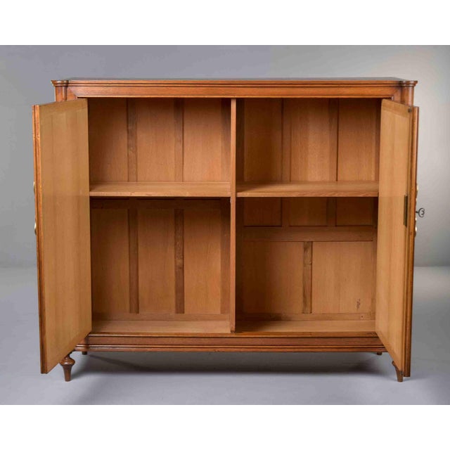 Two-door cabinet featuring striking checkerboard parquetry veneer across the front doors. Distinguished by ornate brass...