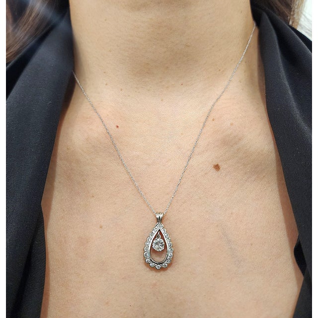 A stunning Art Deco pendant necklace, showcasing the elegance of 1930s craftsmanship. This exquisite piece features a...