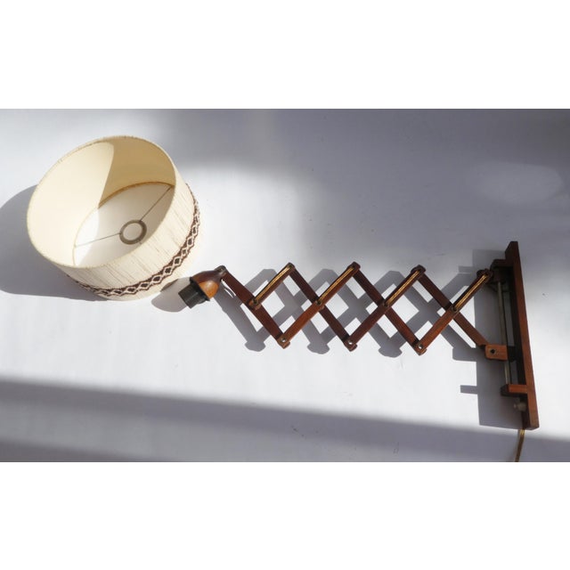 Scandinavian wall scissor lamp made out of teak wood with a nicely decorated fabric shade. The shade is made out of a hard...