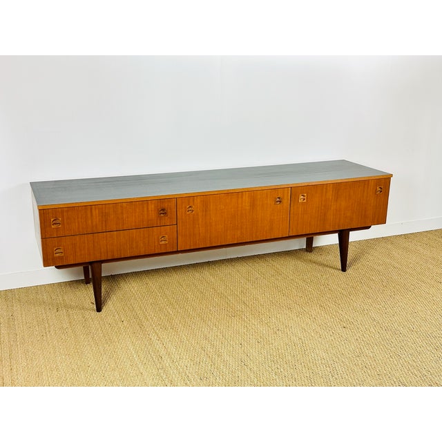 Vintage Scandinavian teak sideboard dating from the 1960s, featuring two hinged doors and two drawers. Black painted top....