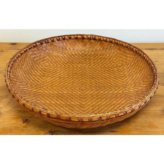 Large round vintage woven wicker basket. Features beautiful rim binding and patternwork to bowl. A wonderfully chic...