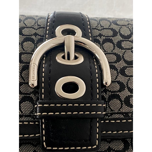 Add a classic touch of Y2K nostalgia to your accessory collection with this authentic Late 20th Century Coach Soho compact...