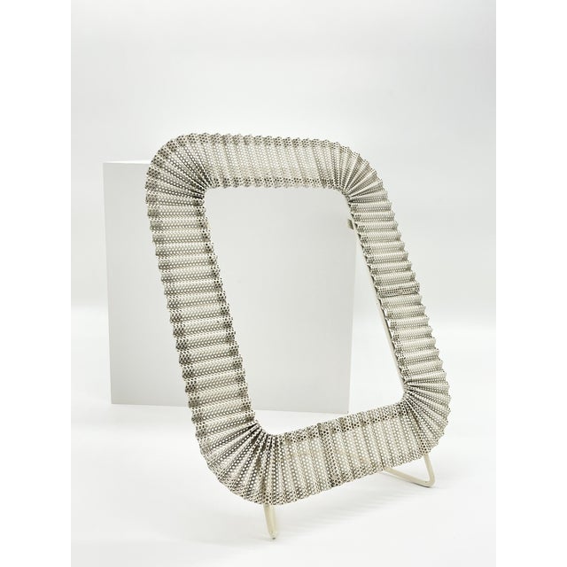 A rare tabletop photographic frame by Mathieu Matégot, a major figure in post-war French design, crafted from perforated...