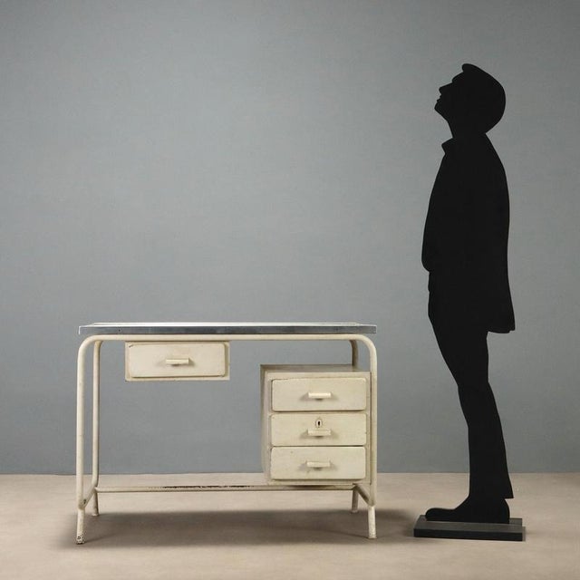 Vintage 1960s metal desk featuring a functional and sturdy design. The structure is made of enameled metal, showing signs...