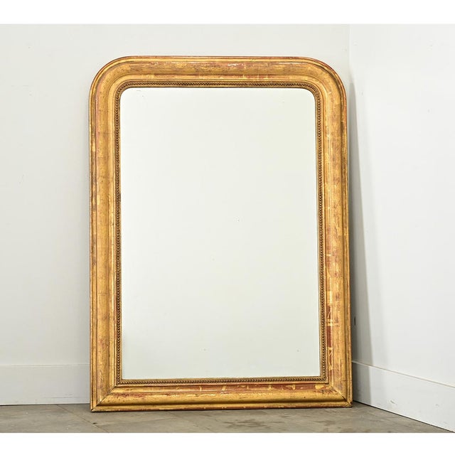 A lovely gilt mirror from 19th century France, the strong proportions of the Louis Philippe style arch-top frame are...