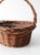 A vintage handwoven wicker gathering basket with a gracefully arched handle and timeless, rustic appeal. Beautifully woven...