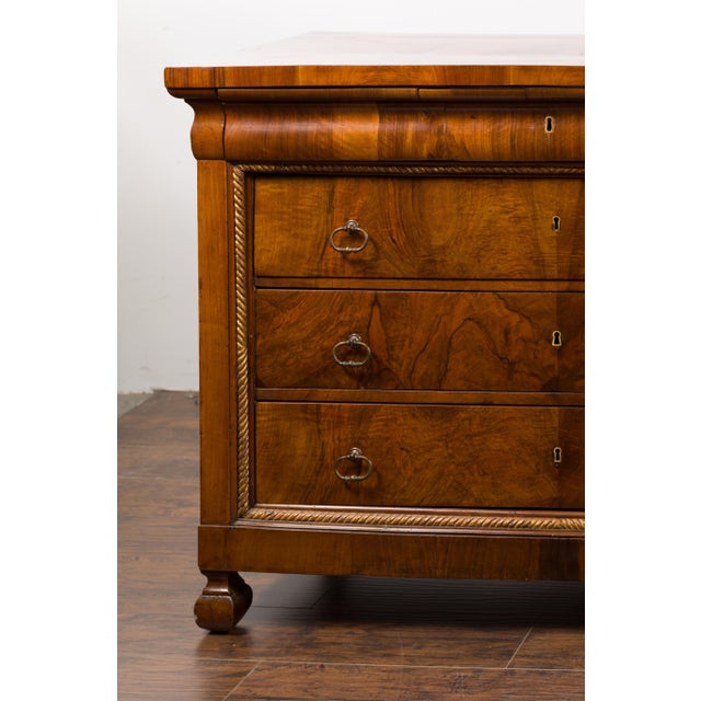 A pair of Italian 18th century walnut commodes with bookmatched veneer, four drawers and petite carved feet. Immerse...