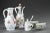 White opaline service set composed of a pitcher, a coffee pot, a mustard pot, and two salt cellars. They are decorated...