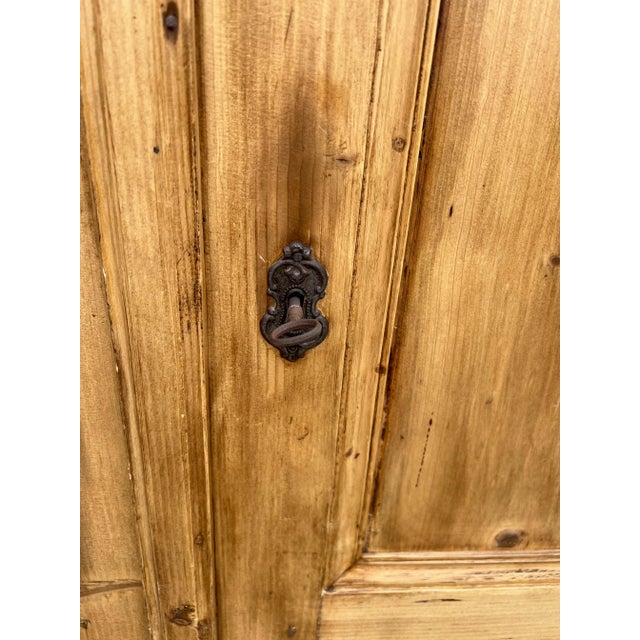 Antique Swedish pine armoire with carved accents and newer garment rod.