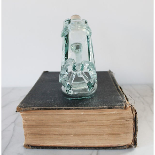 Vintage art glass high heel shoe decanter or bottle with cork stopper. It has a light green hue. No makers mark. I can...