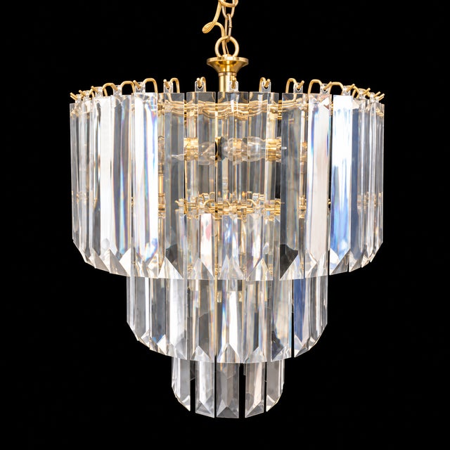 Fabulous set of Mid-Century chandeliers. with clear lucite prisms. The larger chandelier is three tiers and 10 lights. The...