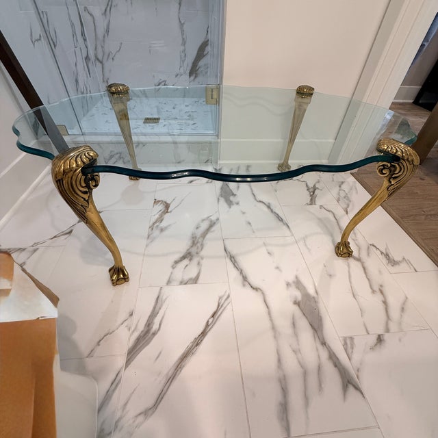 Vintage P. E. Guerin Style Glass Coffee Table with Brass Legs A Hollywood Regency style coffee table, believed to be by...