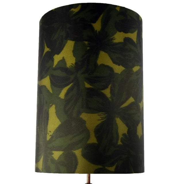 This floor lamp was produced in the 1950s. It features a tripod base and metal stem all with a brass finish. The shade is...