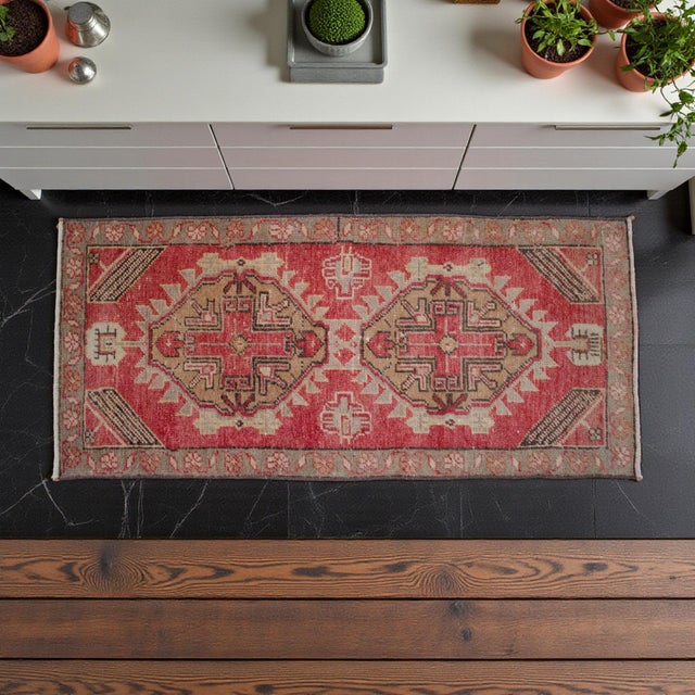 This vintage Oushak rug features a striking medallion design set against a vibrant, sun-faded red field that brings warmth...