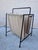 Paul McCobb's Magazine Holder, an authorized reissue by Fritz Hansen in a hard-to-find tan and cream colorway. A slender...