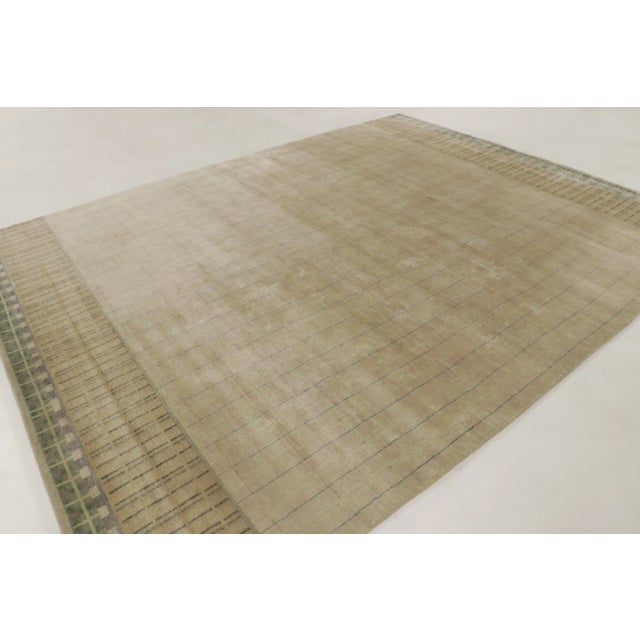 This 9x12 Art Deco geometric rug, hand-knotted in wool, features a softly textured beige field with fine linear detailing...