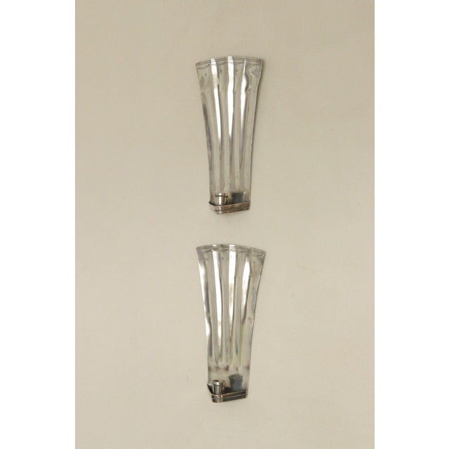 Pair of early 20th‑century Swedish hammered pewter sconces by Tage Fong‑Stedt, dated 1925. The hand‑hammered pewter...