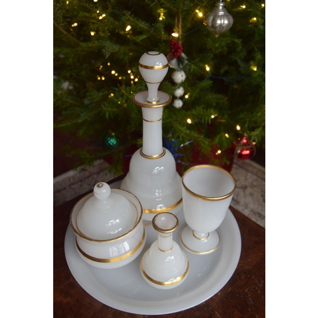 Elegant antique white opaline vanity set with fine hand-applied gold banding, presented on its original matching tray. The...