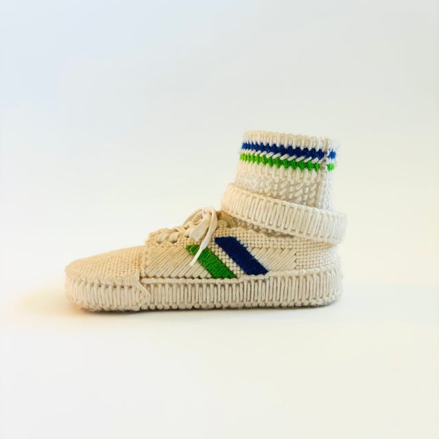A vintage hand made crochet tennis shoe. The ankle part is hollow for storing items. Measures 8.25"W x 3.5"D x 5"H