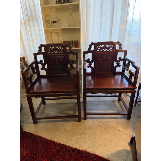 Exquisite pair of solid hand carved rosewood arm chairs. They have a lot of carved decorative elements and very wide deep...