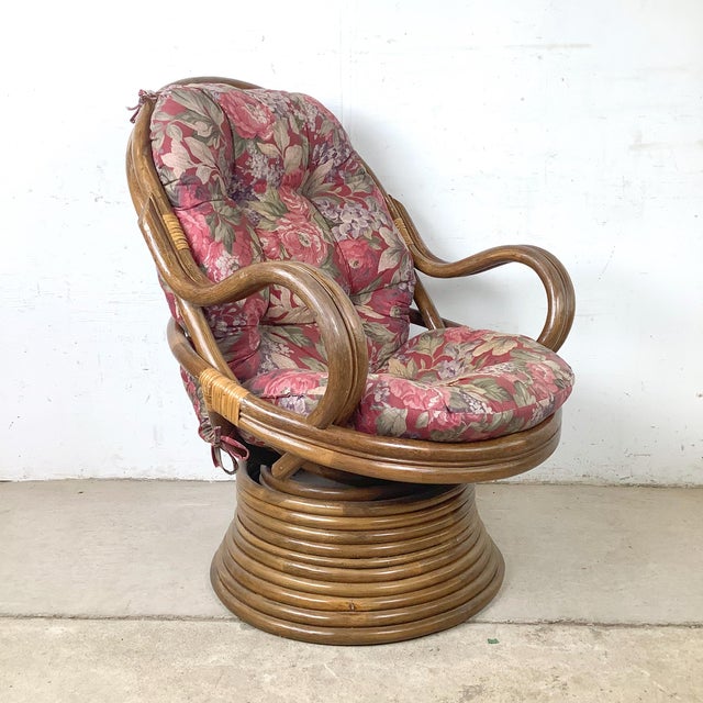 An exceptionally sculptural vintage swivel lounge chair featuring dramatic bentwood arms, woven rattan construction, and a...