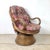 An exceptionally sculptural vintage swivel lounge chair featuring dramatic bentwood arms, woven rattan construction, and a...