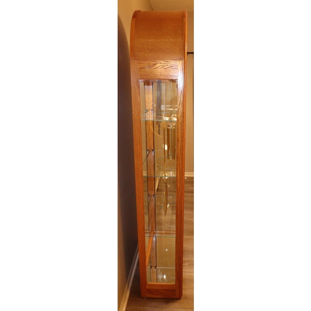 A refined example of late 20th-century American horology, this Howard Miller “Eternity II” curio grandfather clock (Model...