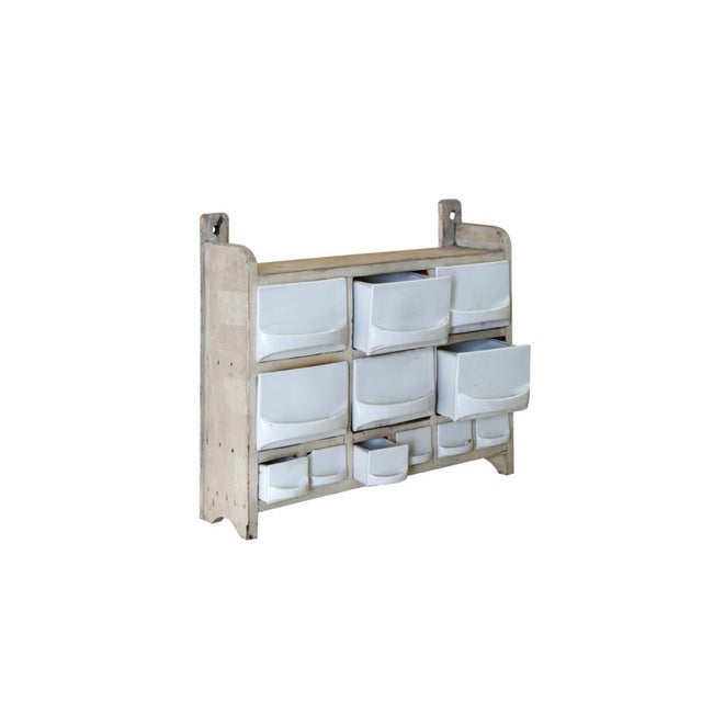 Original spice rack with white lacquered wooden structure and ceramic container drawers. A special object to give that...