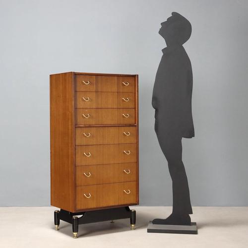 7-drawer chest of drawers, teak veneer, enamelled wooden base, brass feet and handles. This piece is attributed to the...