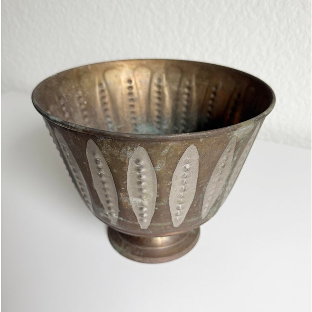 Unique pedestal cachepot planter made of aged copper with an accent of silver-toned, modernist ellipses around the pot....