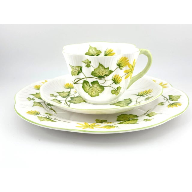 This lovely Shelley trio, Celandine, with yellow flowers, includes a cup, saucer, and plate in Shelley’s iconic Dainty...
