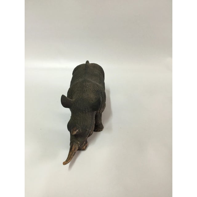 Our noble rhino sculpture shows off the details of the largest safari animal. He is poised with a lowered head in a...