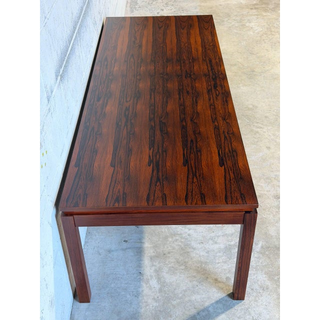 This long rectangular coffee table features a minimalist design with clean, straight lines. Its elegant profile and...