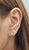 A pair of modern 14K white gold stud earrings featuring approximately 1.00 carat of natural princess-cut white diamonds,...
