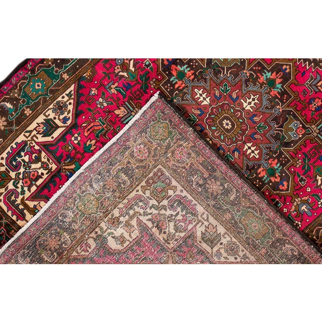 Beautiful Vintage Persian Heriz hand-knotted Wool Rug with a Pink, beige field. This rug has a brown frame and multicolor...