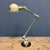 Beige two-arm Jieldé table lamp. This early variant features a short arm, a feature rarely seen. Designed by the French...