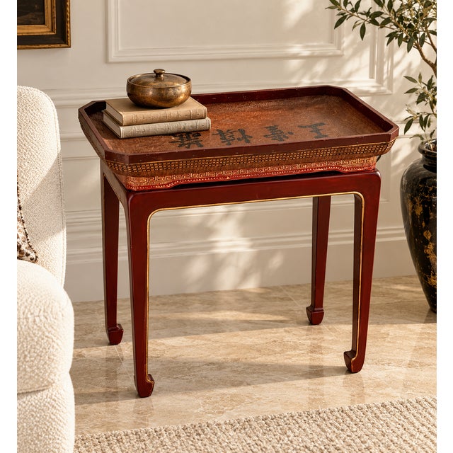 A distinctive vintage Chinese tray table featuring a removable rectangular serving tray resting on an elegant lacquered...