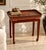 A distinctive vintage Chinese tray table featuring a removable rectangular serving tray resting on an elegant lacquered...