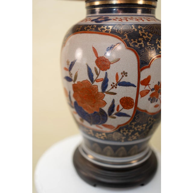Elegant and richly detailed, this vintage Imari-style porcelain lamp features hand-painted florals in hues of navy, burnt...