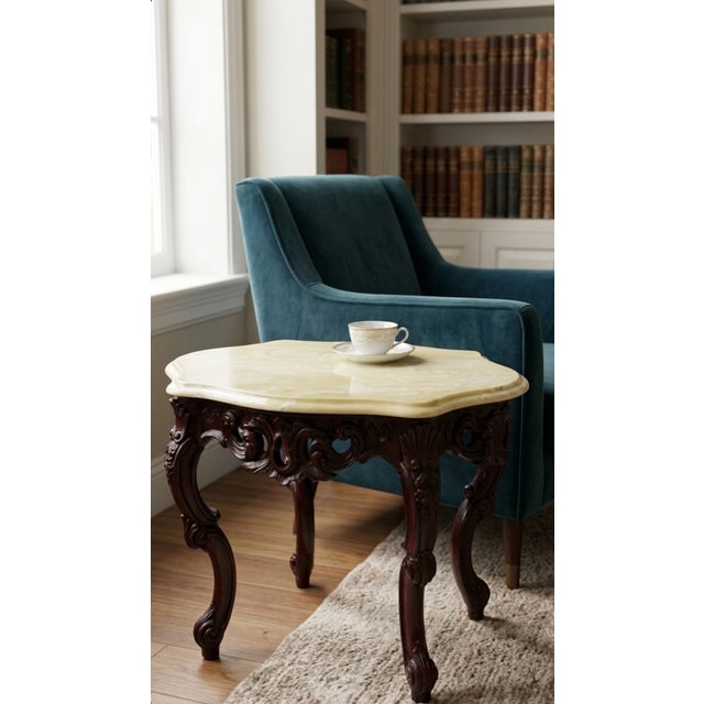 Elegant vintage accent table featuring a richly carved dark mahogany-finish wood base with classic Rococo-inspired...