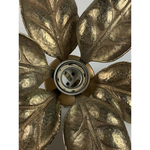 A brass floral florentine wall sconce attributed often to willy daro for massive lighting, belgium 1970s. This iconic wall...