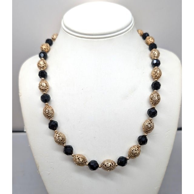 1960s single strand alternating goldtone ovoid filigree beads with black cut glass beads with small smooth spherical...