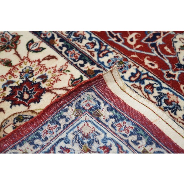 The palmette arabesquerie of the ecru field moves in close to the ragged red medallion, and then pulls away a little....